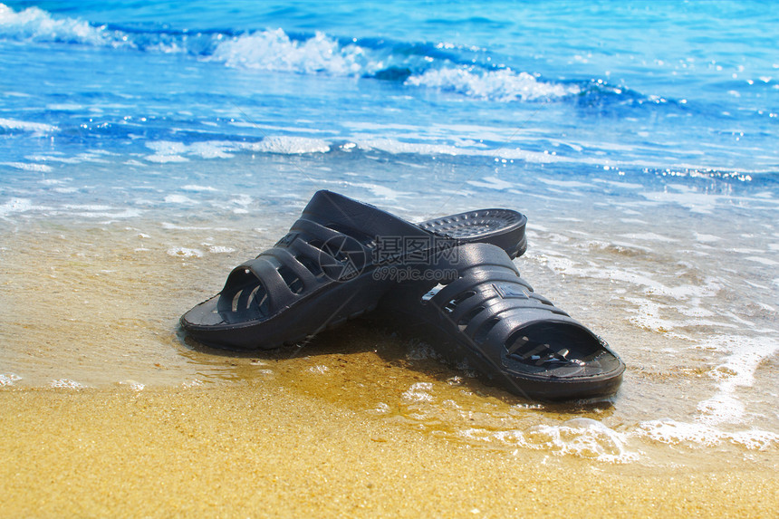 沙滩上的运动鞋鞋类水平热带假期蓝色海洋阳光旅行支撑海岸图片