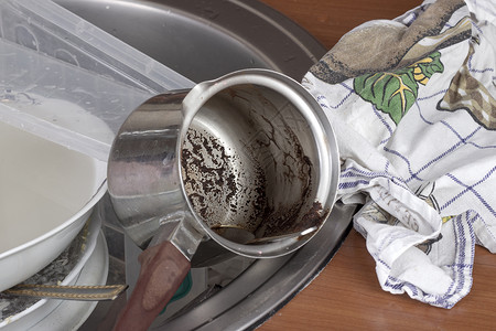 脏抹布水槽中的脏盘子玻璃家庭平底锅刀具家务剩饭水平杯子剩菜积累背景