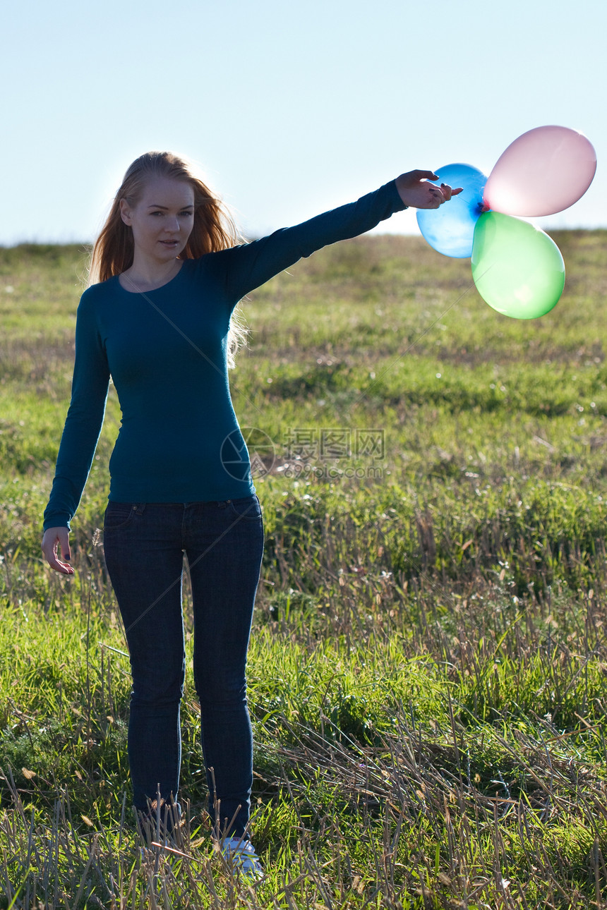 露天有气球的年轻美少女太阳幸福团体蓝色天空假期头发背光场景微笑图片