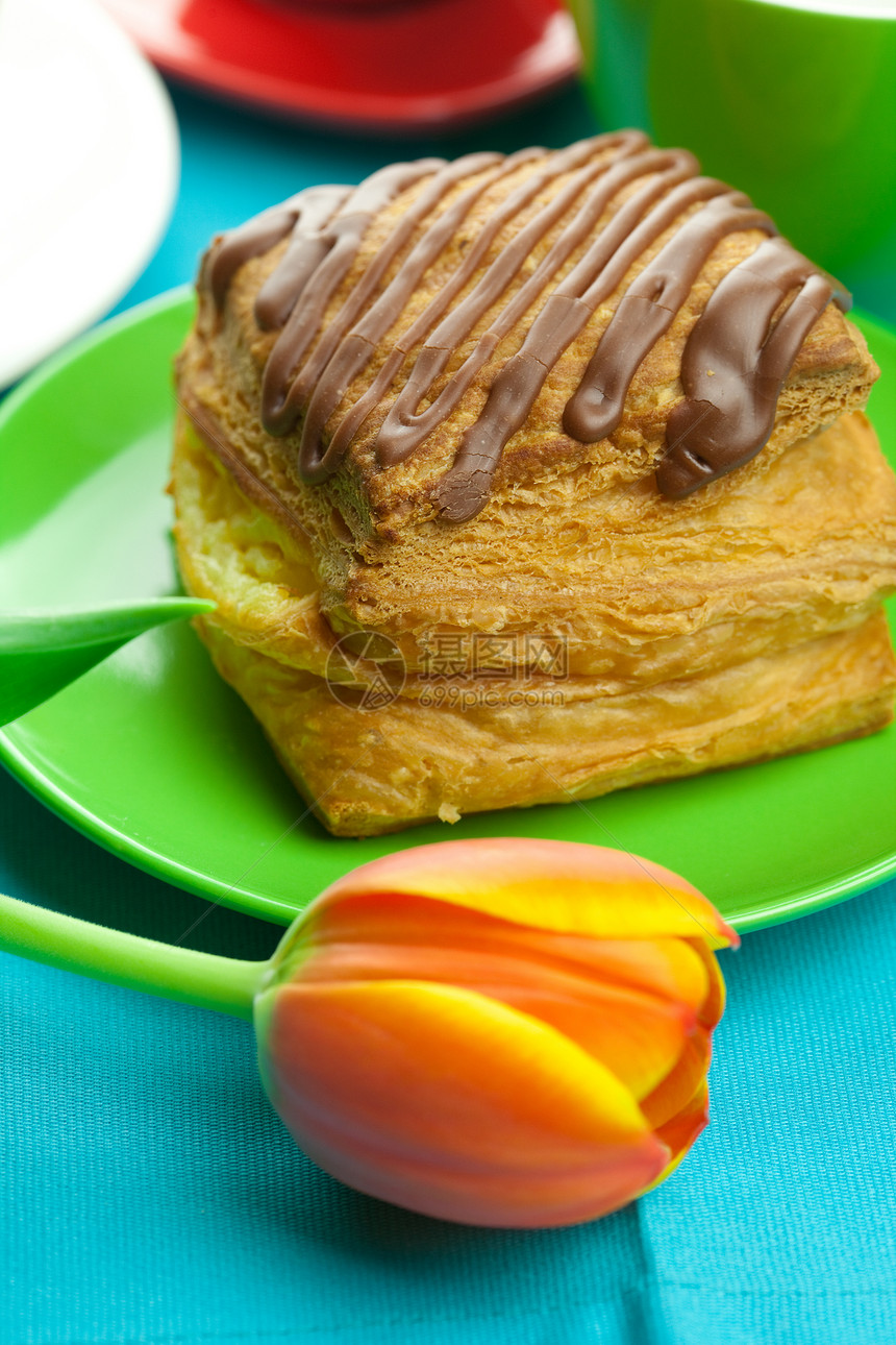 餐盘上加巧克力的蛋糕 郁金香和布料上的杯子糕点文化阴影厨房烘烤植物糖果食物面包早餐图片