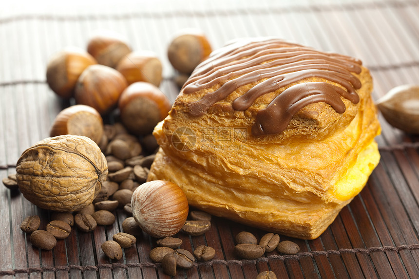 巧克力蛋糕 咖啡豆和坚果 放在竹垫上咖啡水果种子团体面粉小麦木头金子面包植物图片