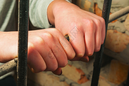 手放在铁栏后面死亡酒吧细胞监狱局限犯罪监禁孤独囚犯惩罚背景图片