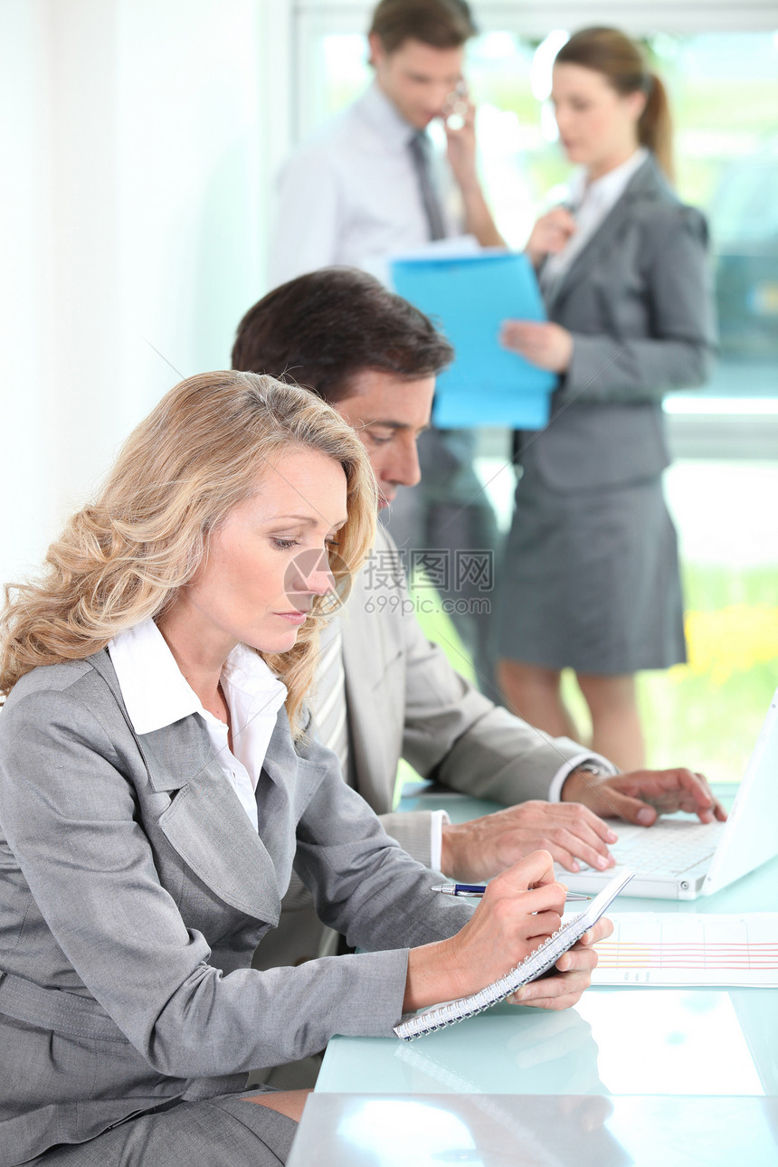 女性在办公室环境中用笔记纸写字图片