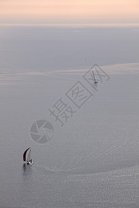 游艇天气风帆赛车训练太阳水手们帆板日落赛马场背景图片