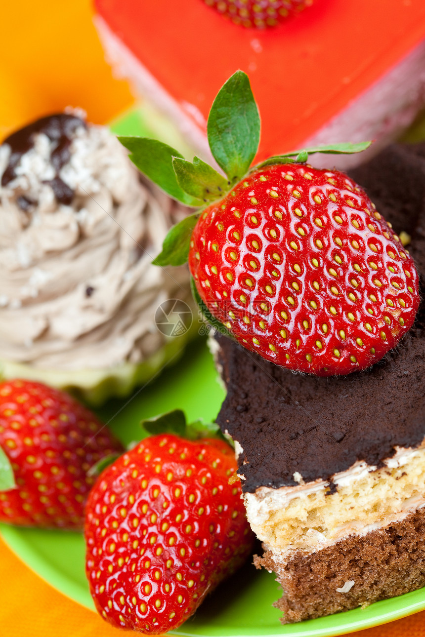 橙色织物上躺着的草莓和蛋糕糖果巧克力美食早餐甜点奇异果叶子糕点浆果奶油图片