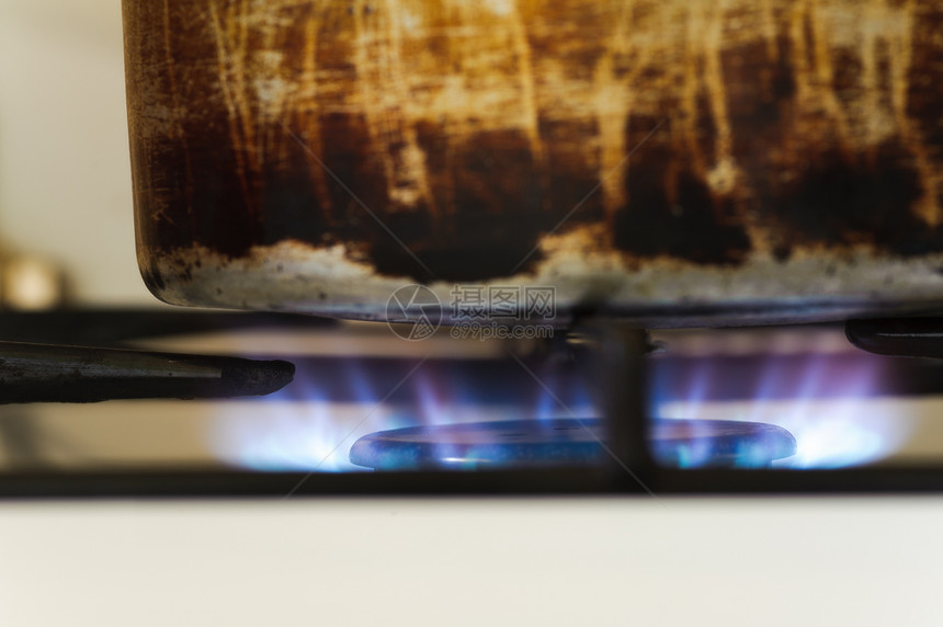 煤气炉子上的老生锈的烧锅 燃烧着火图片