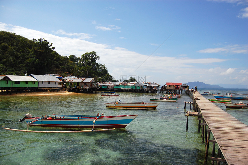 印度尼西亚装有柔孔船的木材镇码头图片