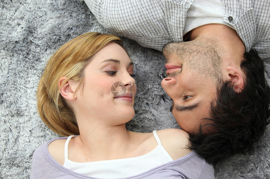 躺在地毯上的一对夫妇衬衫灰人成年人活力妻子金发女郎青年乐趣伙伴反应图片