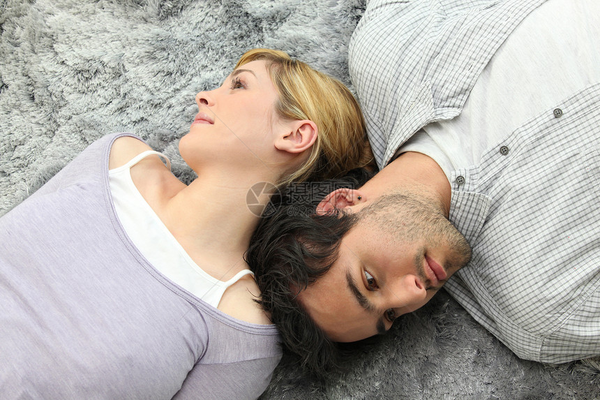 躺在地毯上的一对夫妇性情男性平行挂毯女性金发女郎拉伸白色衬衫紧张图片