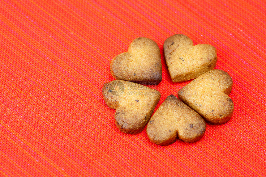 以红背景的盘子中的心形 cookie 形式芯片小吃团体织物纺织品食物红色生活美食牛奶图片