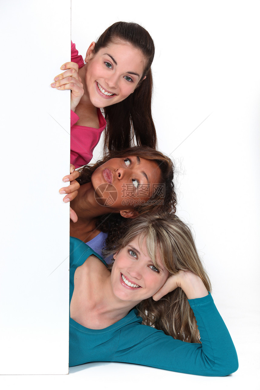 三名年轻妇女在白板后面图片
