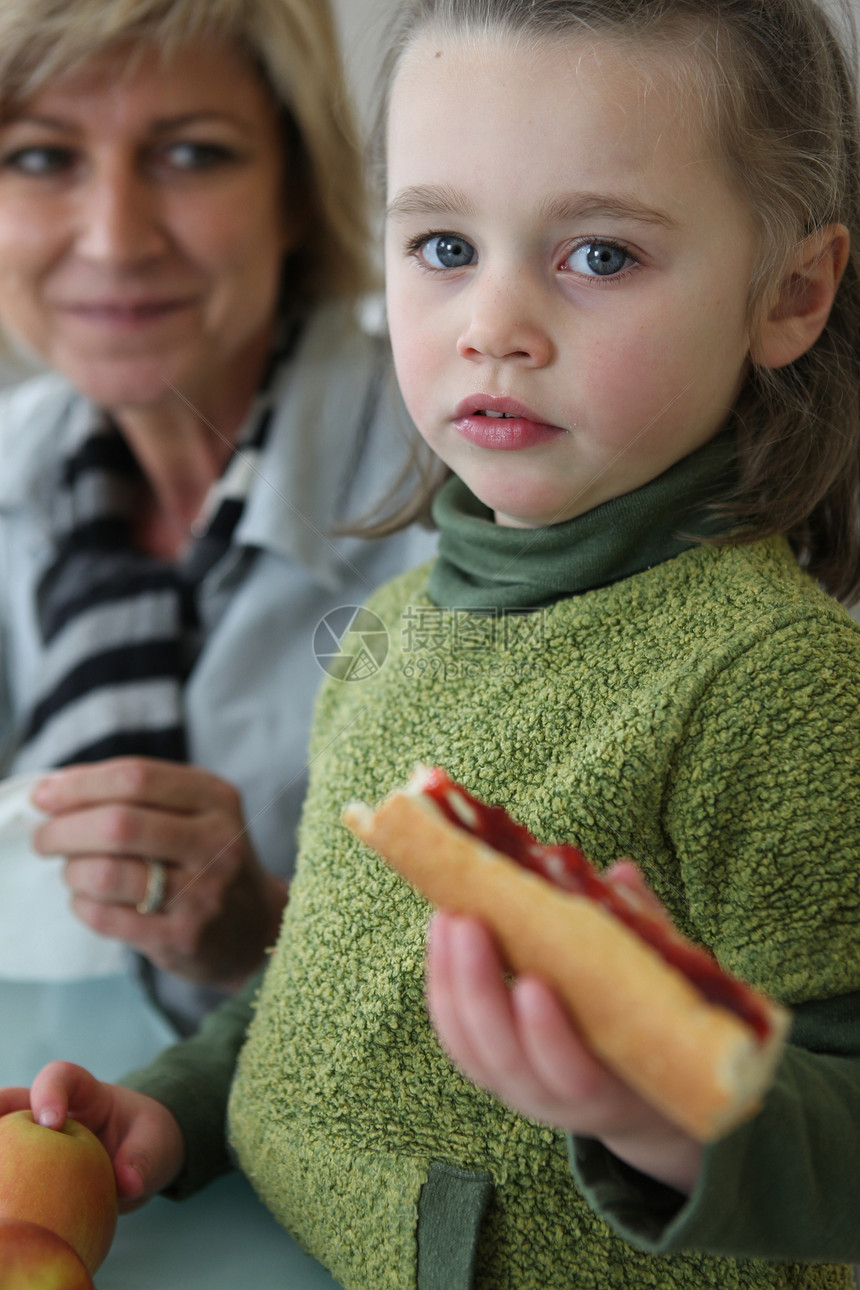 小女孩和妈妈一起吃三明治的图片