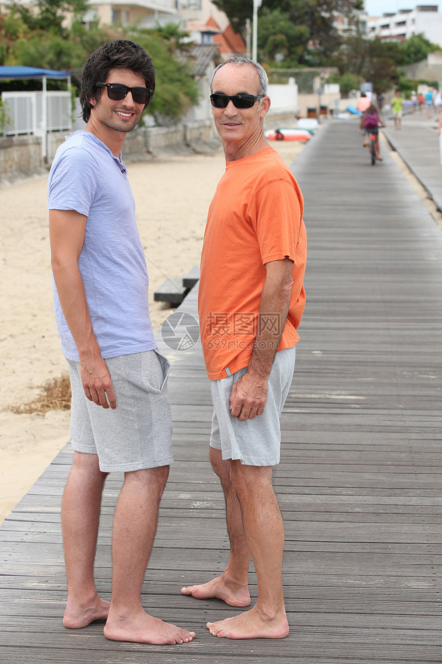 祖父和孙子在沙滩上散步图片