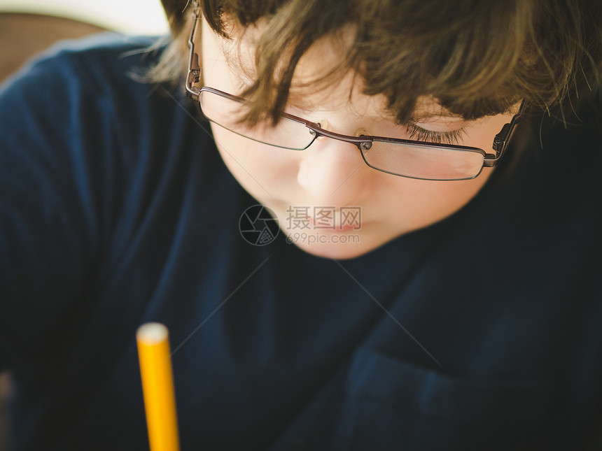 男孩做功课孩子们眼镜男性孩子青年童年专注草图写作铅笔图片