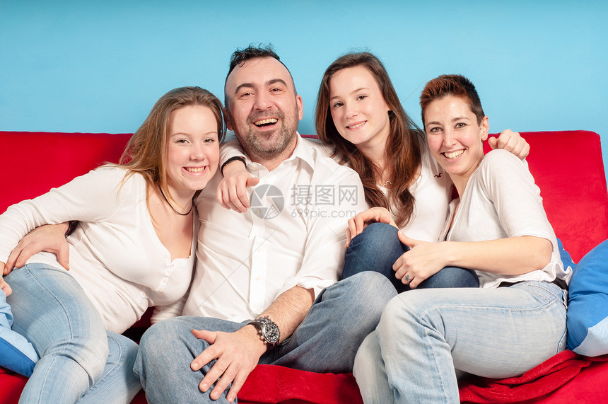 幸福的家庭在沙发上父亲牛仔裤女性女儿乐趣女孩男生母亲感情青少年图片
