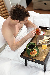 男人一个人在床上吃早餐高清图片