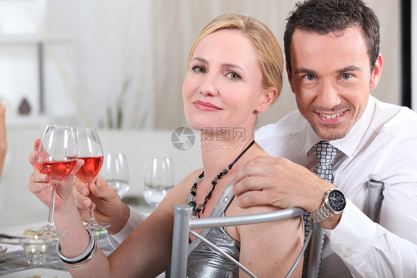 在晚宴上加玫瑰酒的情侣图片
