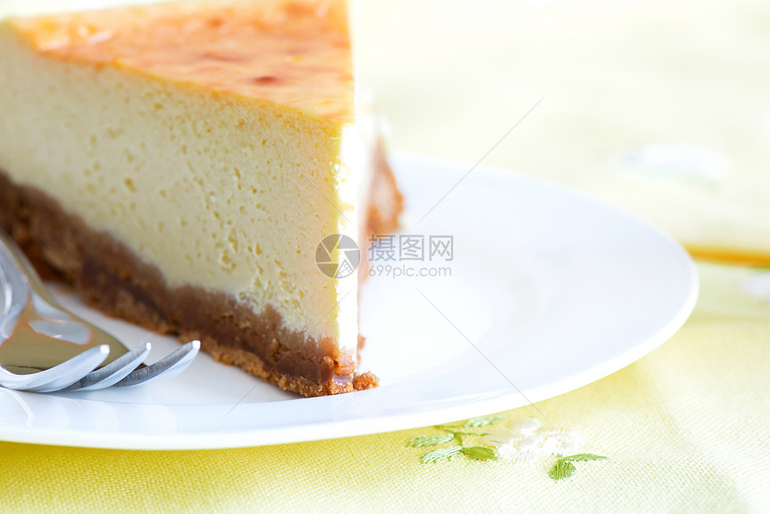 芝士蛋糕和蛋糕叉子 在餐桌布的盘子里图片