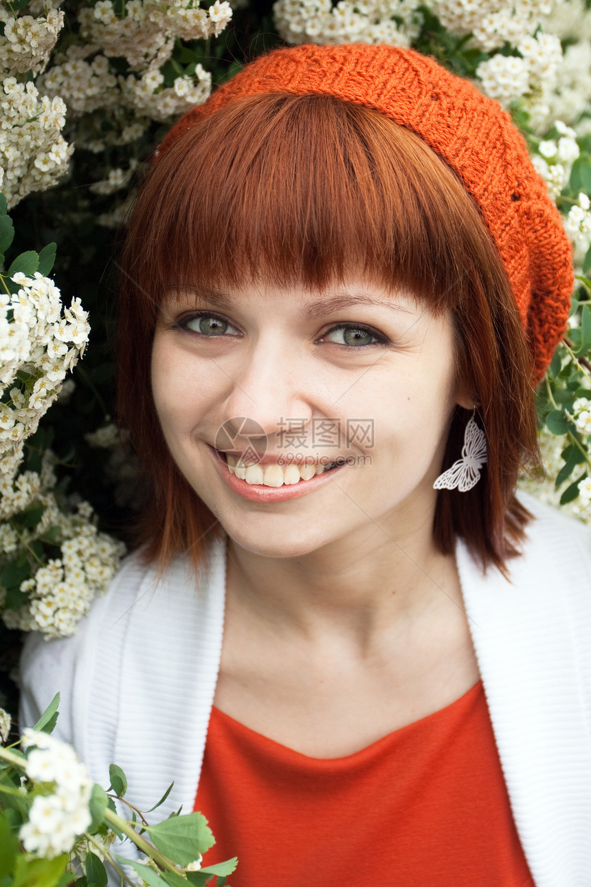 一个年轻美丽的女孩的肖像 穿着橘子针织贝雷帽橙子楼梯微笑花园红色夹克公园树叶绿色围巾图片