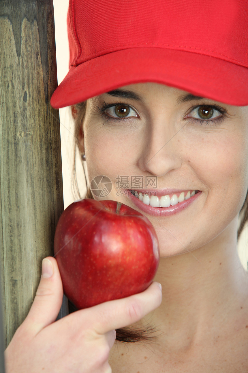 戴帽子和吃苹果的女子图片