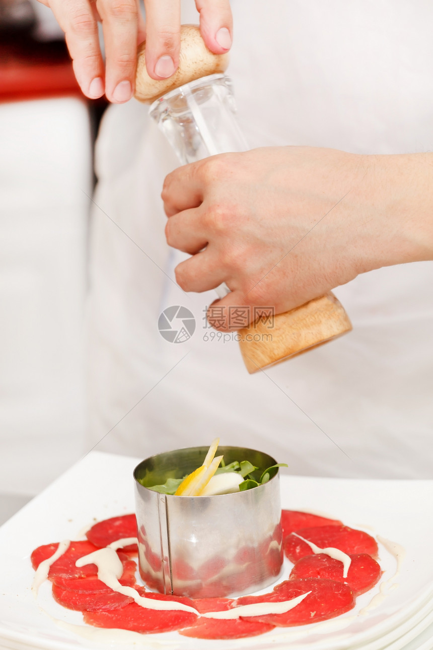 制作calpaccio的厨师盘子叶子餐厅沙拉草药奢华胡椒午餐牛肉片厨房图片