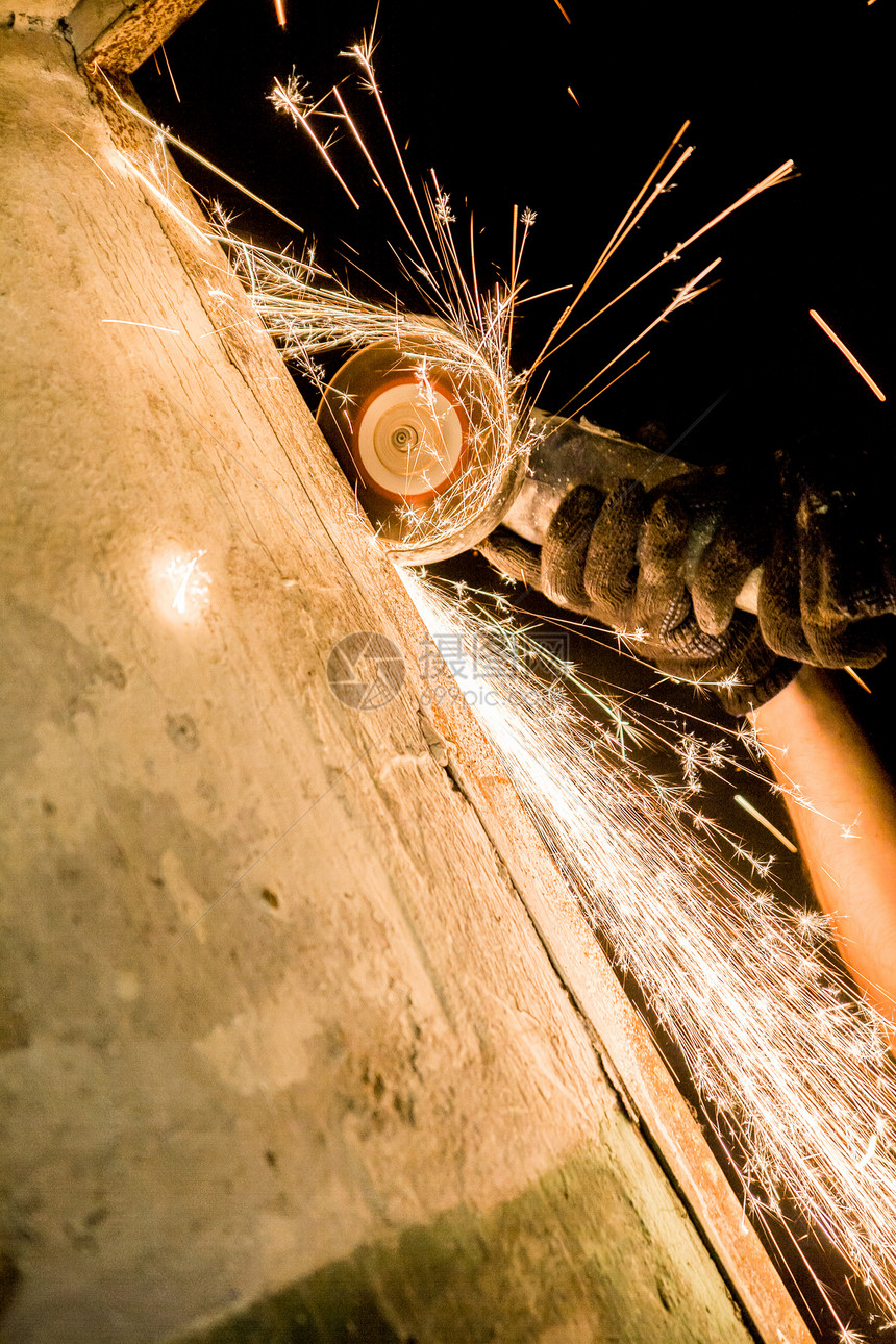 手握旋转圆形锯的男子磨床制造业工艺工具力量生产机械金工火花工业图片