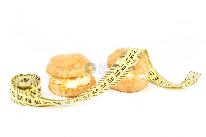 缩水 焦糖蛋糕和测量胶带的概念磁带损失糖果重量减肥小吃焦糖奶油数字面包图片