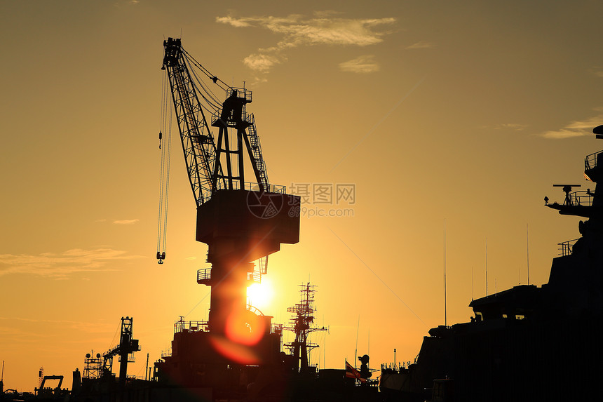 日落时停靠在码头的起重机尾巴机械螺旋桨船尾雕刻制造业修理货物海洋货运图片