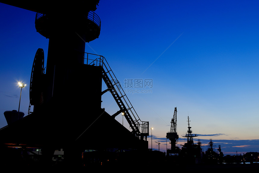 日落时停靠在码头的起重机运输避风港机械后勤港口贸易货运龙门架金属天空图片