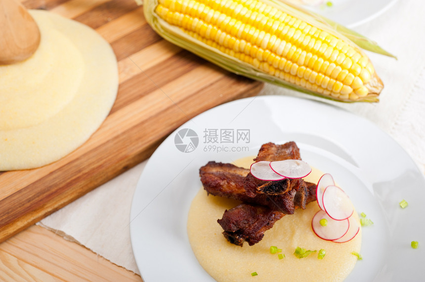 波伦塔玉米奶油床上的猪排草药肋骨午餐美食蔬菜红色棒子面奶油餐厅玉米图片