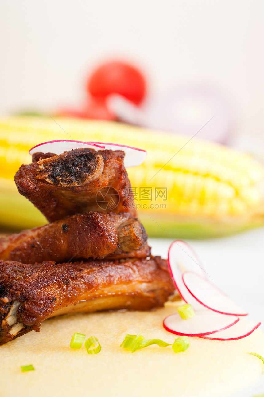 波伦塔玉米奶油床上的猪排食物盘子油炸蔬菜餐厅棒子面草药玉米肋骨午餐图片
