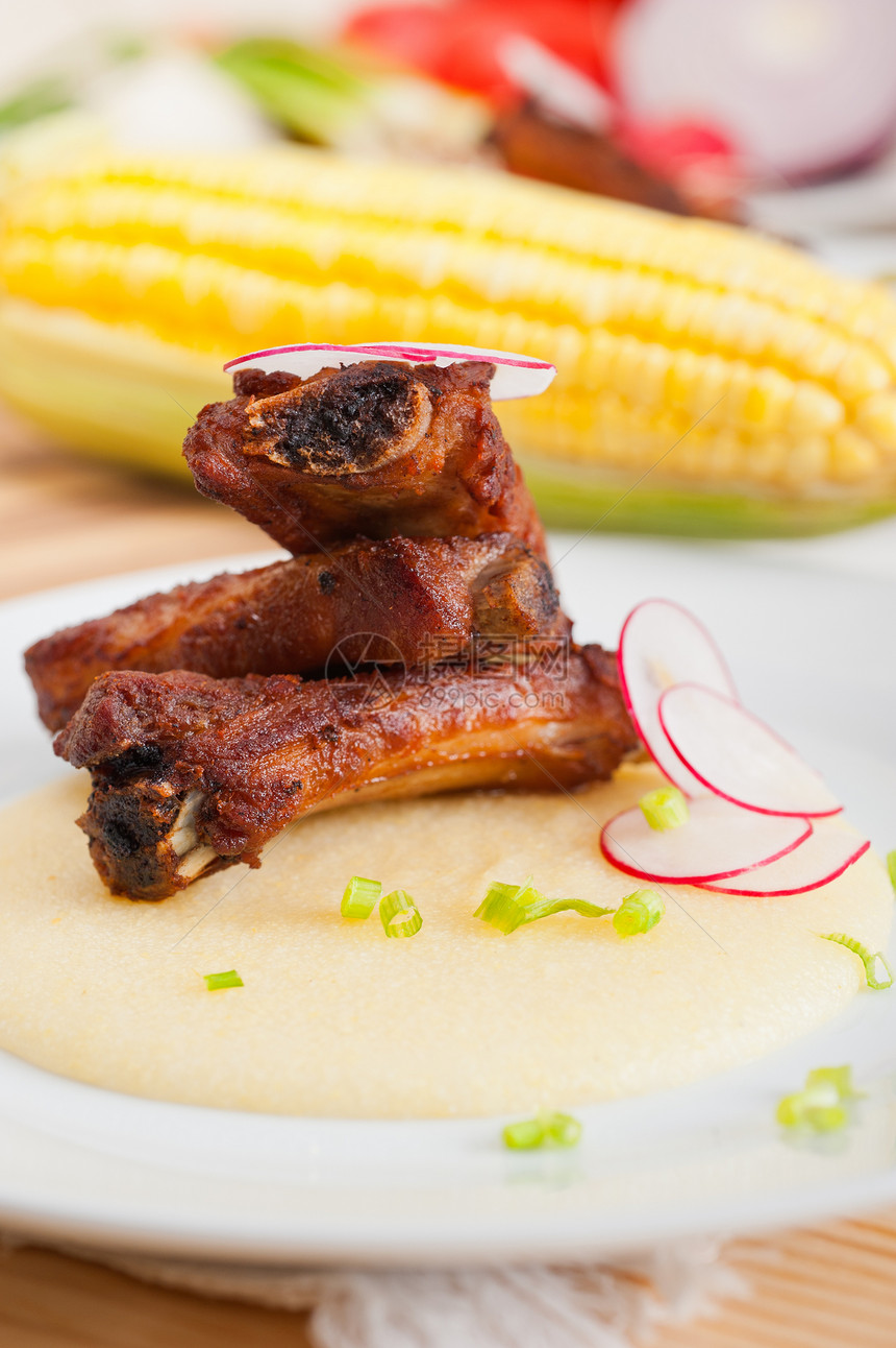 波伦塔玉米奶油床上的猪排午餐奶油美食油炸肋骨草药红色玉米棒子面空闲图片
