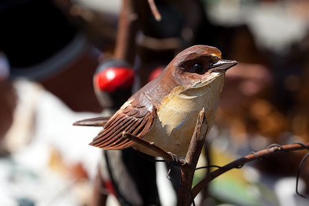 在集市的树枝上的陶瓷鸟羽毛粮食零售乌鸦精神文化市场希望艺术木头背景图片