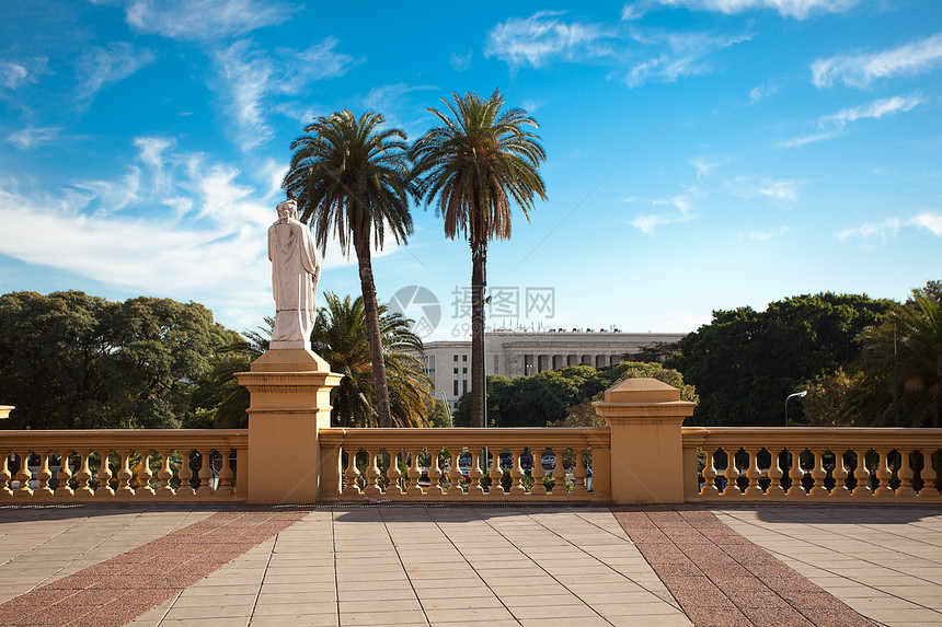 在棕榈树和蓝天空背景上挂有雕像的阳台酒店花园躺椅家具圆顶天空叶子建筑公园衬套图片