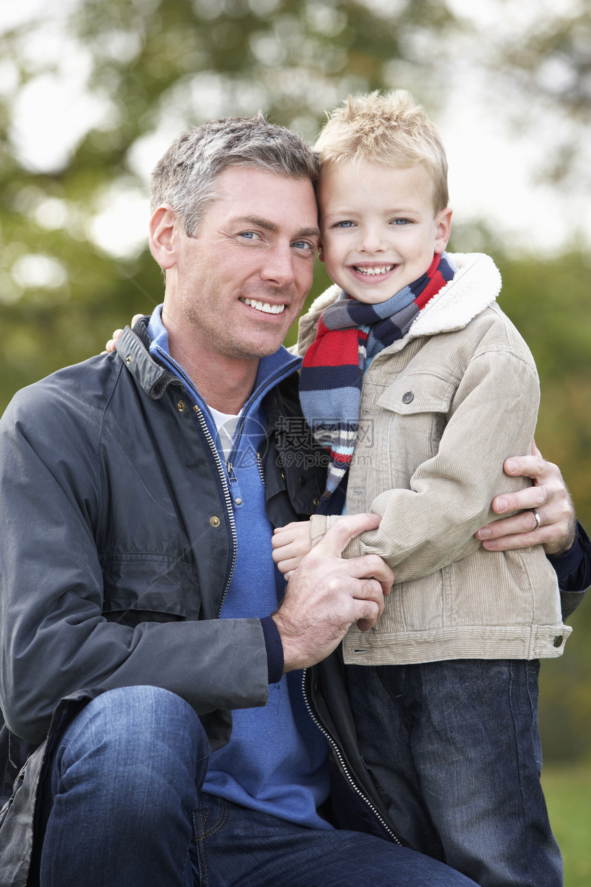 父亲和儿子抱抱 在外门秋日散步男人中年男生男性宠物公园微笑拥抱图片