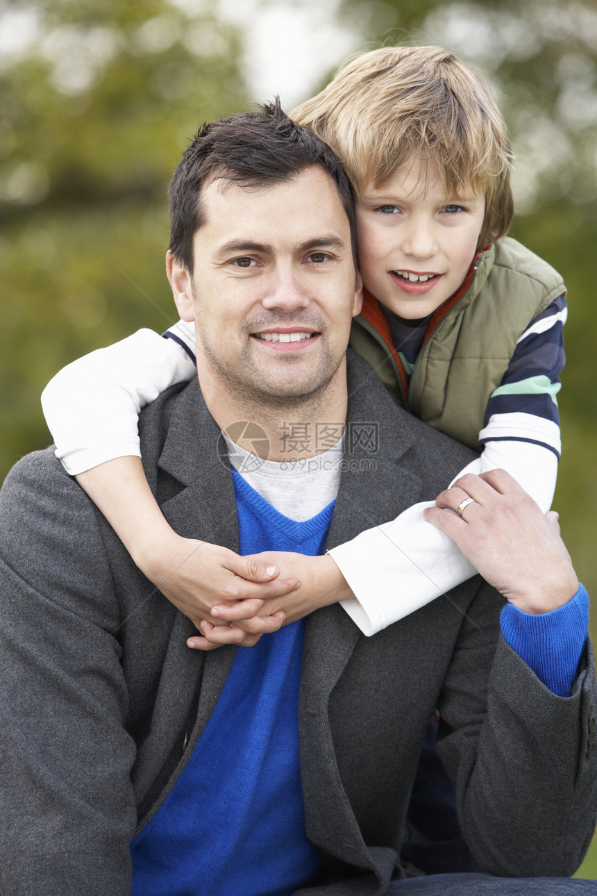 父亲和儿子抱抱 在外门秋日散步男性微笑中年宠物男生男人拥抱公园图片
