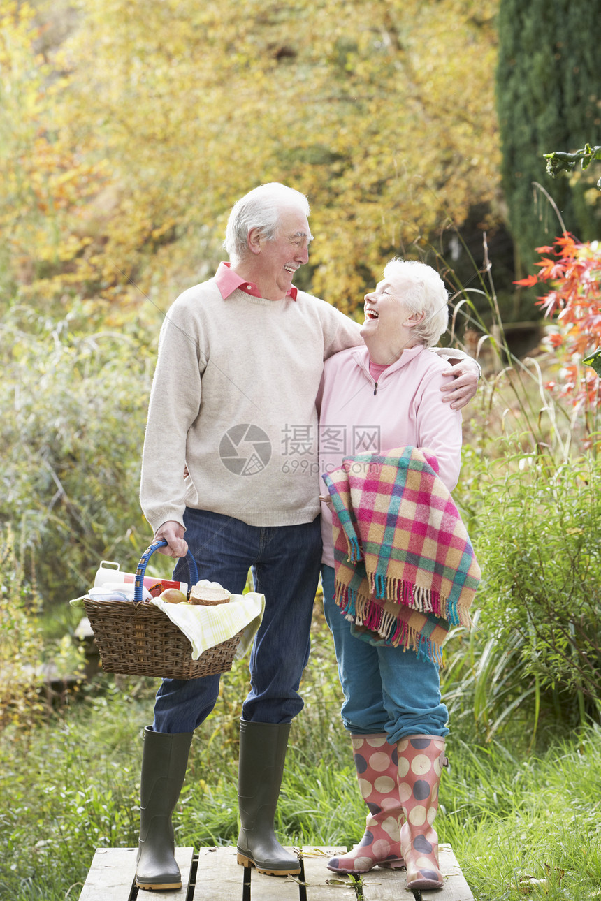 秋天林地边上带烧烤篮子的老年夫妇户外野餐男人丈夫男性感情女性农村毯子树叶女士图片