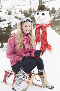 冬天滑雪雪人下至雪人与滑雪女孩天气女性寒冷雪橇青少年季节围巾笑声下雪微笑背景