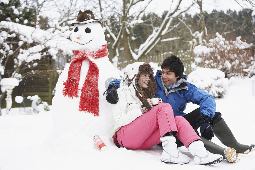 冬季风景中的青少年情侣 下到雪人金发女郎季节金发女性男生烧瓶笑声微笑寒冷滑雪镜图片