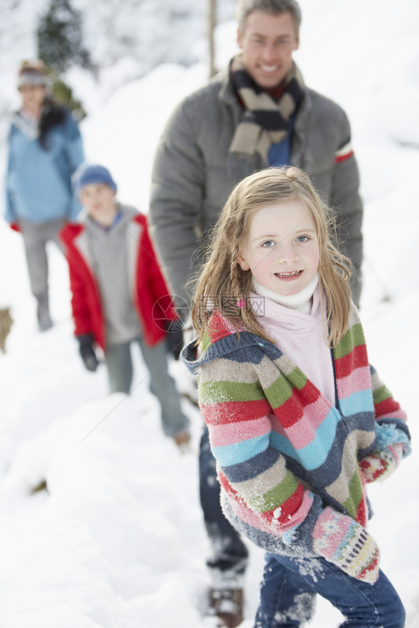 享受在雪地风景中漫步的家庭下雪混血场景孩子女士围巾季节四个人寒冷场地图片