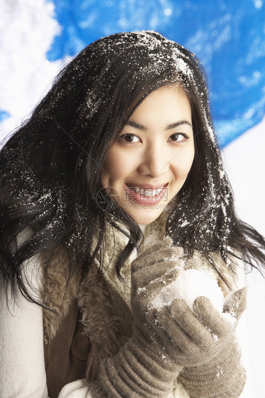 在斯图德身着雪球的穿着温暖温冬衣的年轻女子天气季节手套衣服围巾羊毛女性金发笑声微笑图片
