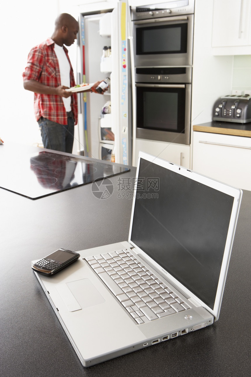 现代厨房用笔记本电脑修理厨房的草纸长度办公冰箱电冰箱男性电话冲浪成人居家细胞图片