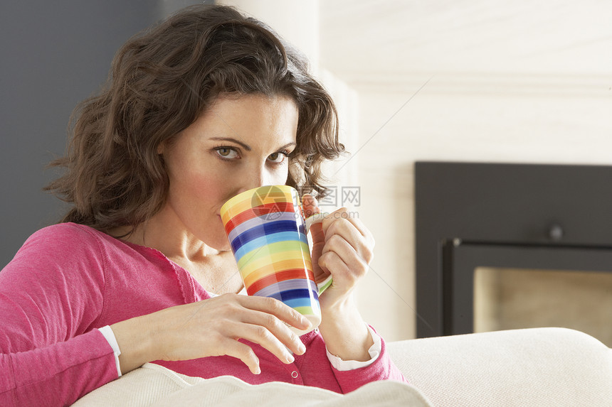 在家喝杯咖啡时在沙发上放松妇女成人享受客厅一杯茶热饮微笑女性长度水平杯子图片