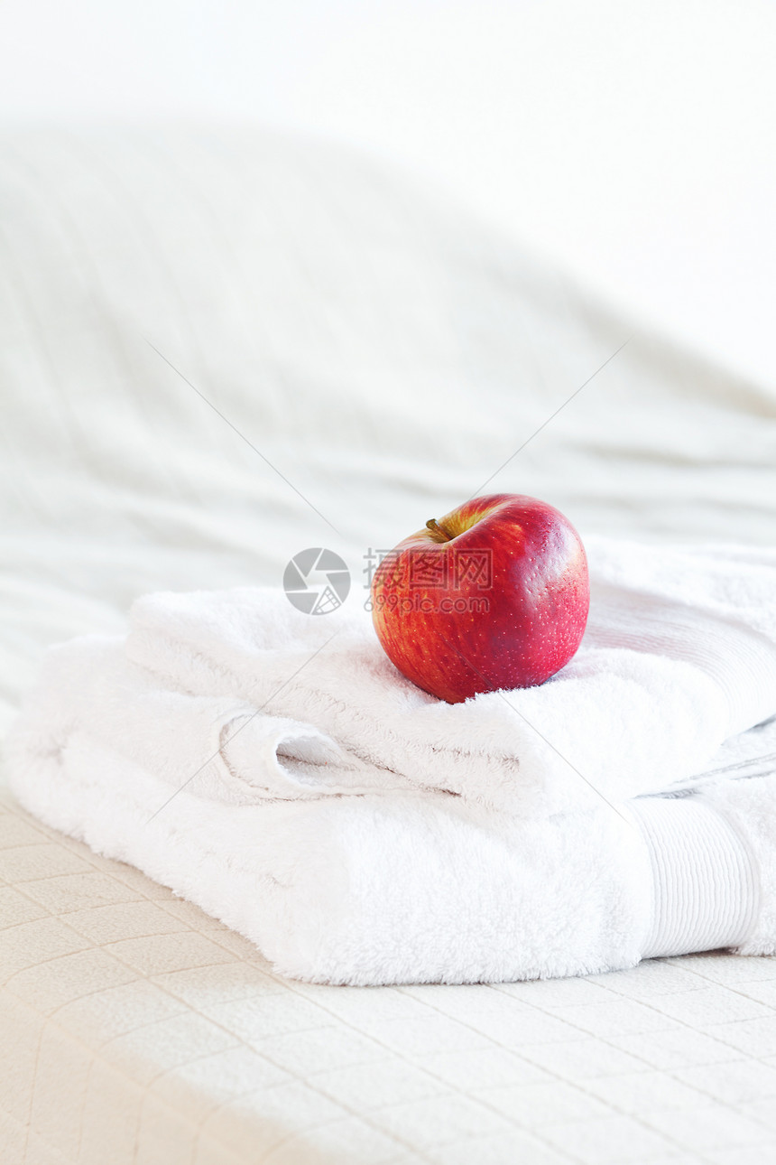躺在床上毛巾上的苹果床单寝具卧室气氛木头客栈国王酒店停留窗帘图片