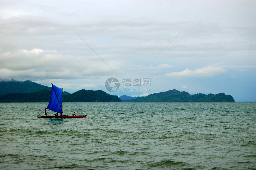 海上蓝帆帆独木舟图片