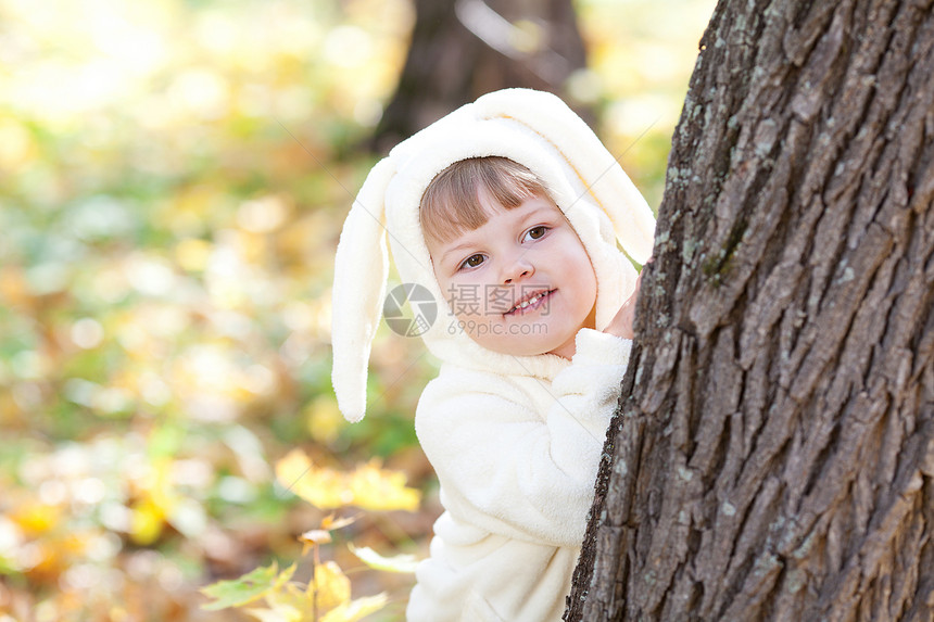 秋天森林中穿着装扮小兔子的漂亮女孩毛皮女儿戏服季节童年喜悦公园幸福橙子微笑图片