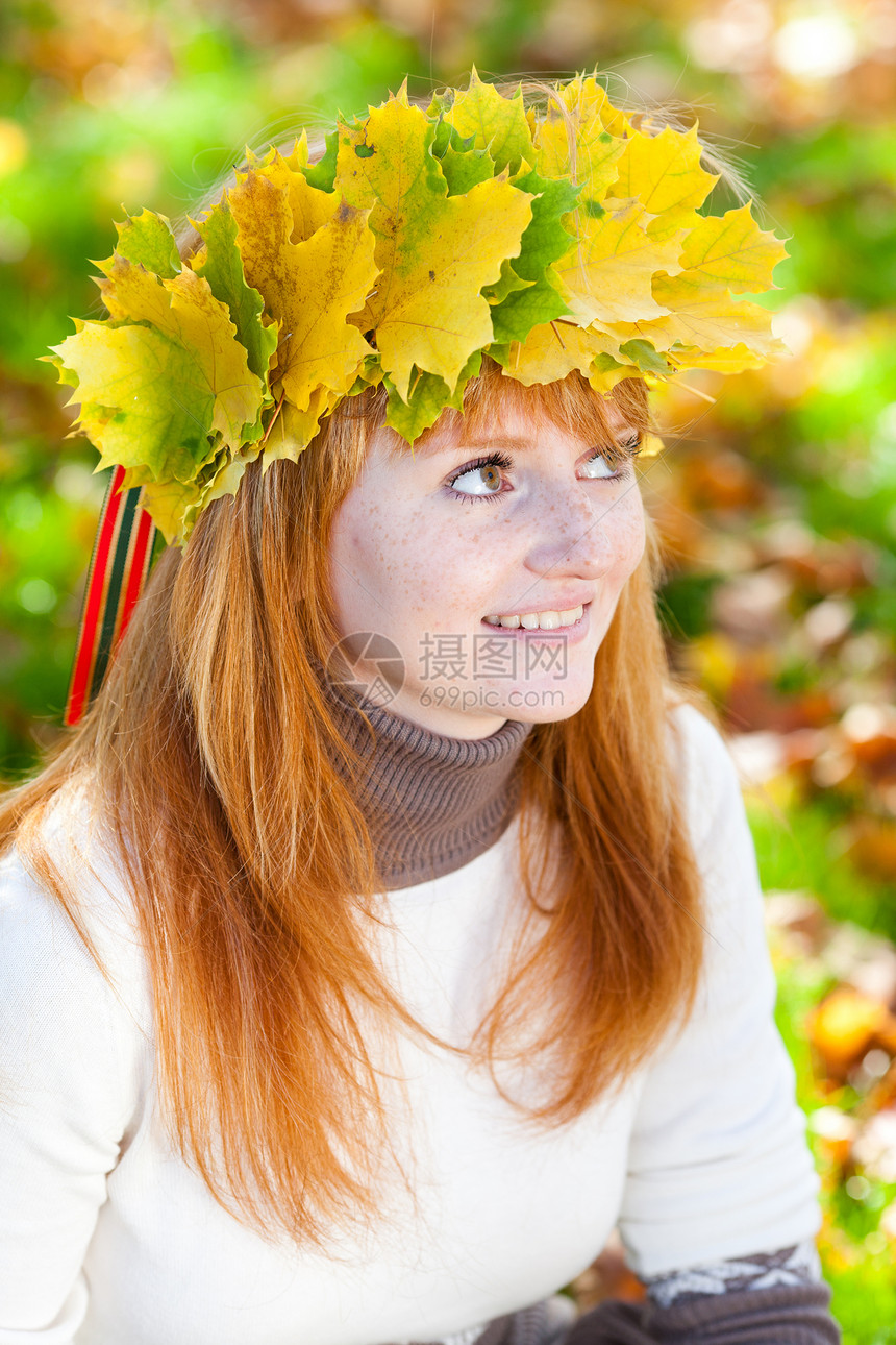 一位美丽的年轻红发女青年 在花圈的肖像叶子金子喜悦成人学生女孩微笑森林幸福乐趣图片