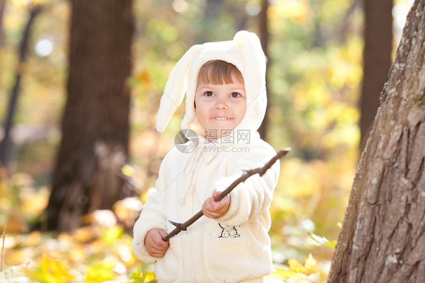 秋天森林中穿着装扮小兔子的漂亮女孩女儿橙子叶子女孩微笑戏服公园季节毛皮兔子图片