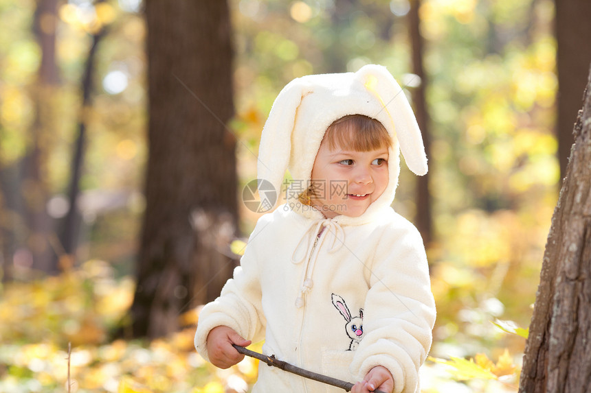 秋天森林中穿着装扮小兔子的漂亮女孩微笑孩子喜悦压痛快乐女性叶子女孩戏服季节图片