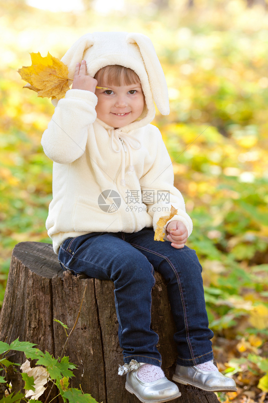 秋天森林中穿着装扮小兔子的漂亮女孩橙子女孩微笑季节乐趣幸福孩子公园喜悦叶子图片